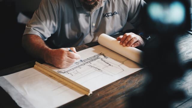 Architect reviewing commercial building plans on a blueprint